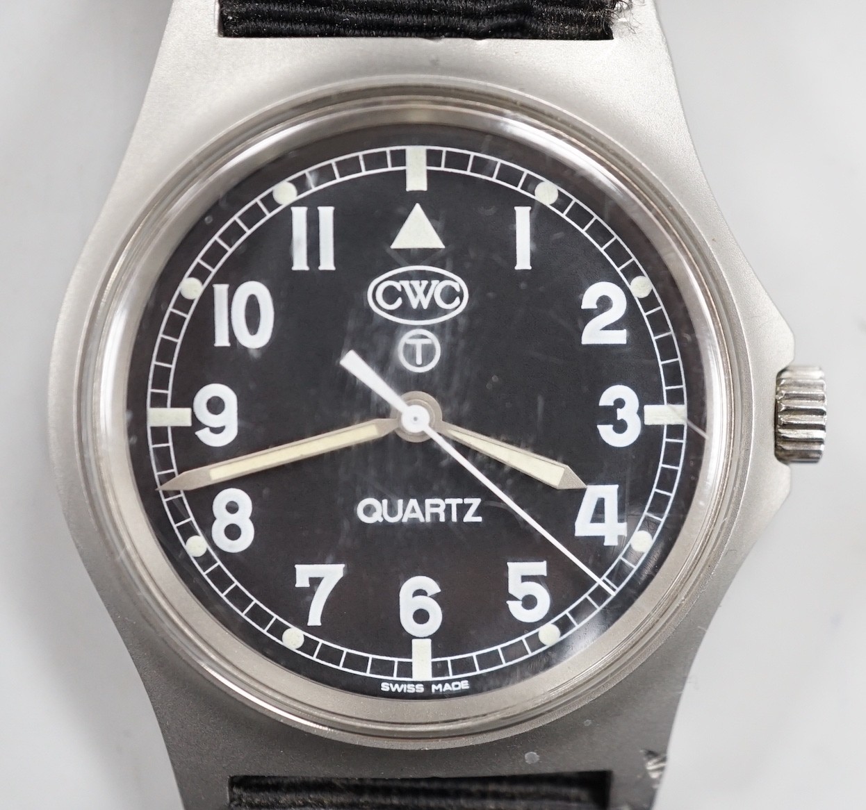A steel? military CWC pilot's quartz wrist watch, with black Arabic dial, the case back with broad arrow and numbered, 0552/6645-99 over 5415317 over 45825 over 89, on a black fabric strap.
